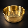 AURORA hand-hammered brass pet food bowl with the Embers Elements logo engraved inside, dark studio background