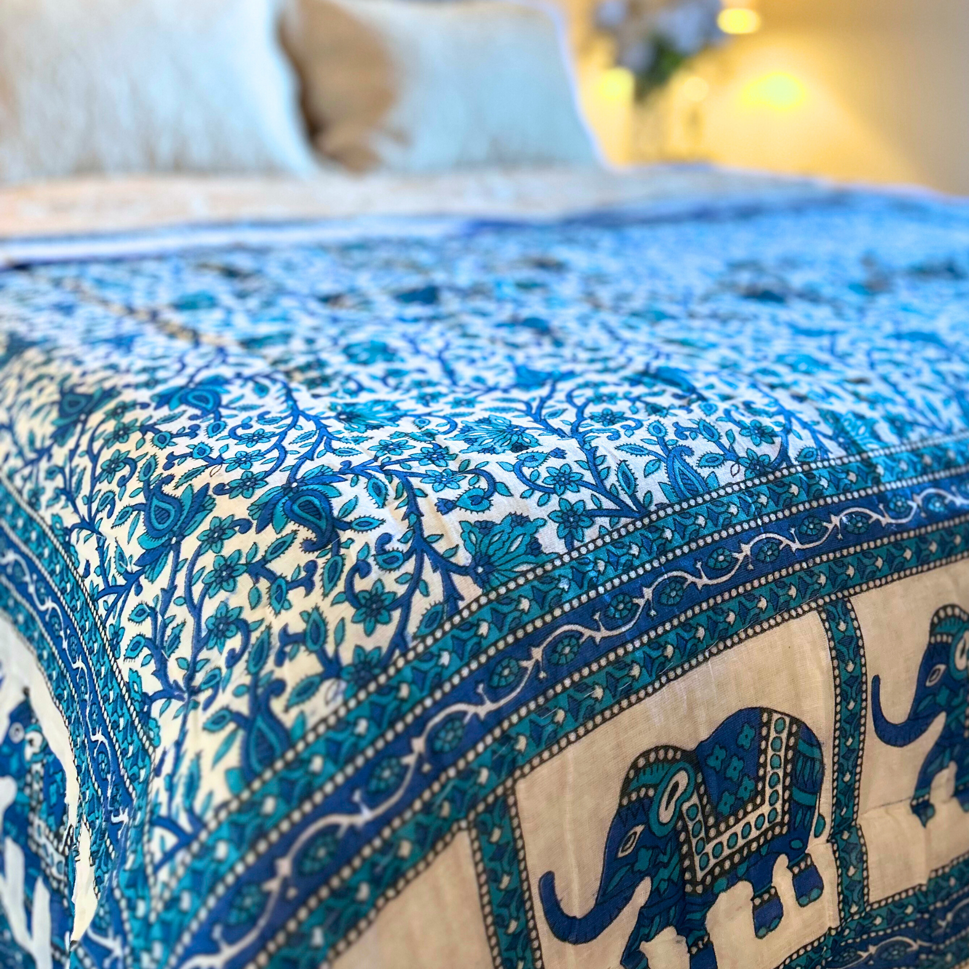 Handcrafted cotton quilt with Jaipuri floral design and blue elephant border.