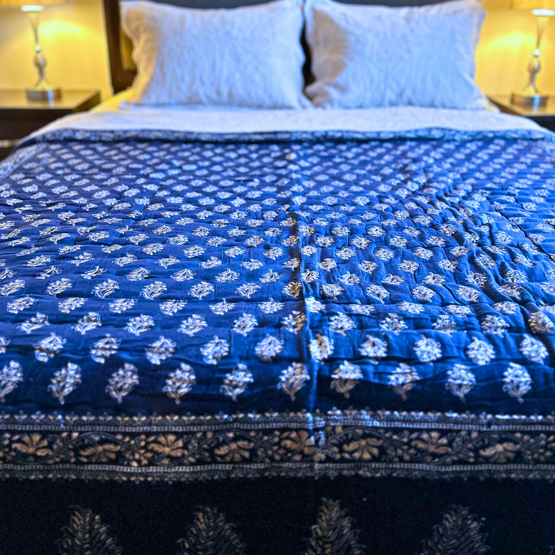 Deep blue cotton quilt with block print design.