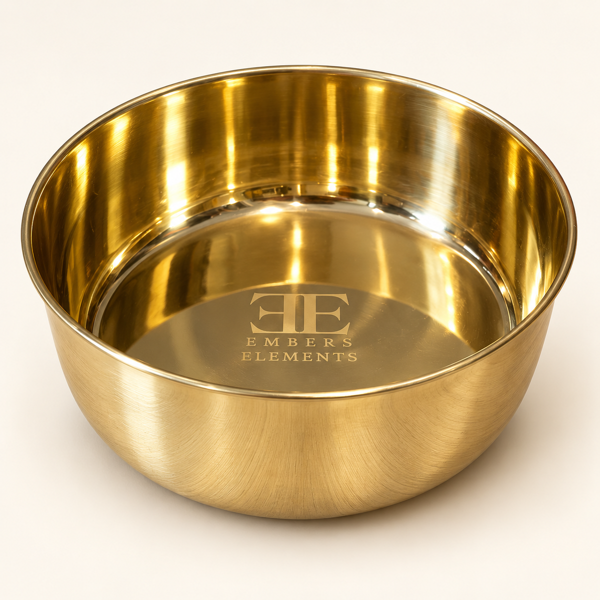 Golden Retriever lying near the DUNE smooth-finish brass pet food bowl on a woven mat with an olive branch