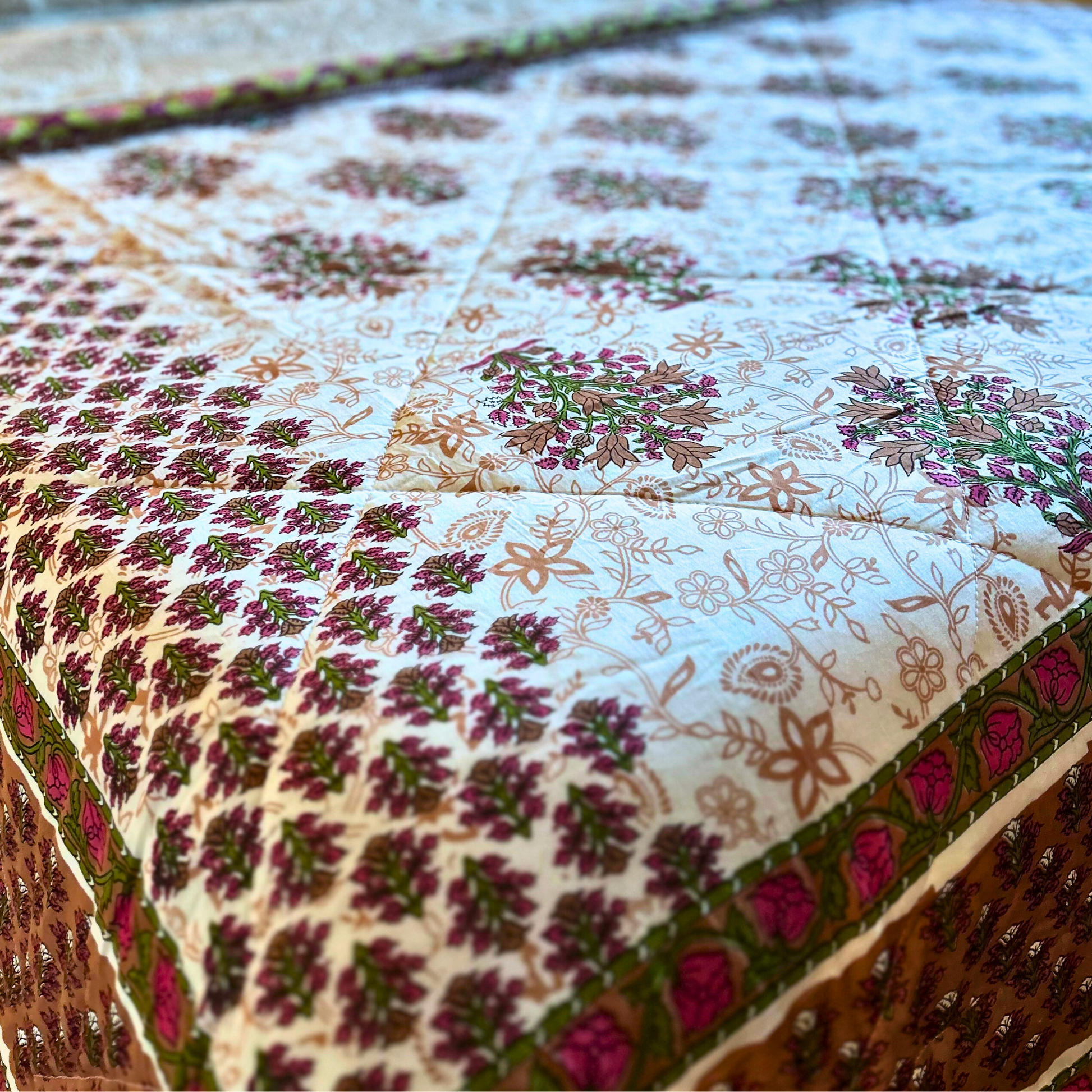 Elegant floral pattern on a reversible cotton quilt.