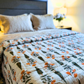 Handcrafted Jaipuri reversible cotton quilt in orange and green.