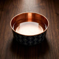 Close-up of DAMASK copper pet bowl filled with water, showing pure copper interior and navy damask exterior