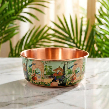 PALACE hand-hammered copper pet water bowl with green and cream peacock and elephant pattern on a marble table