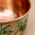 Angled view of empty PALACE copper pet bowl showing the full peacock and elephant palace pattern exterior