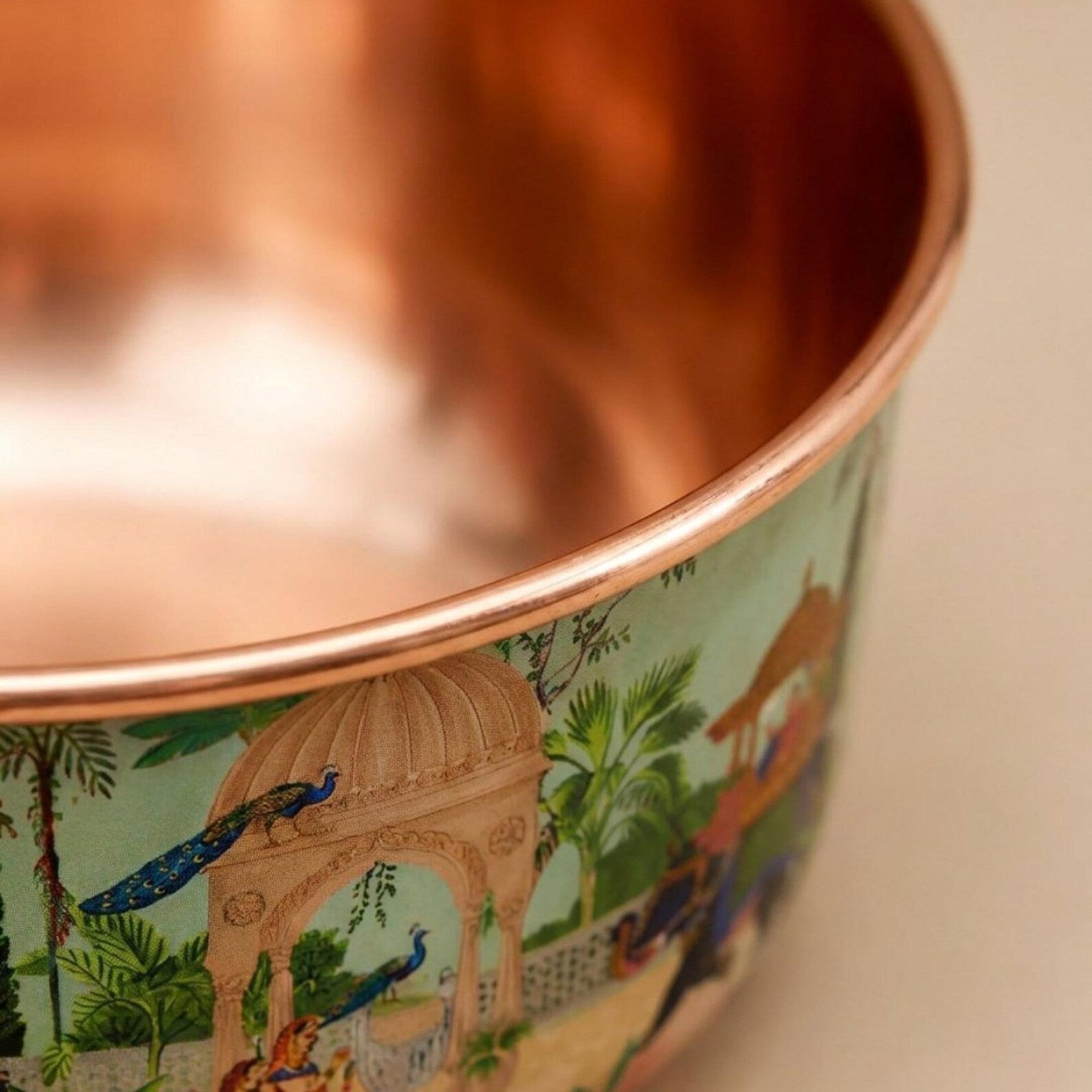 Angled view of empty PALACE copper pet bowl showing the full peacock and elephant palace pattern exterior