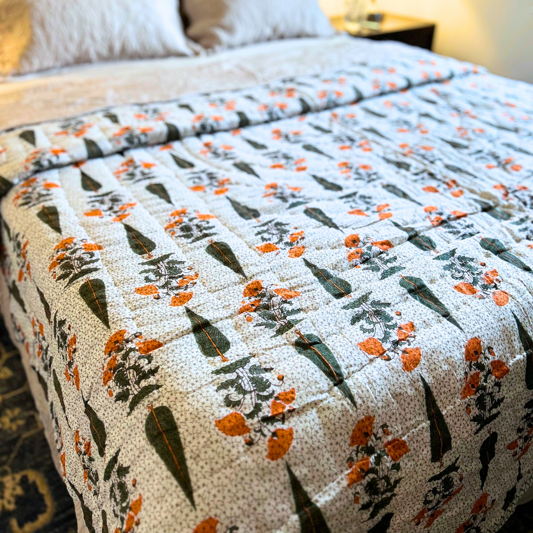 Handcrafted Jaipuri reversible cotton quilt in orange and green.