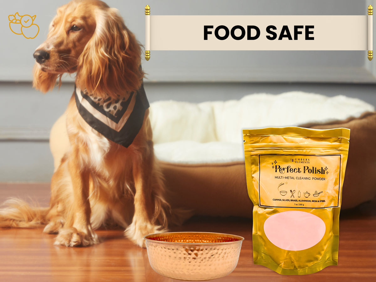 Dog sitting next to a copper bowl and a package of Perfect Polish cleaner on a wooden floor