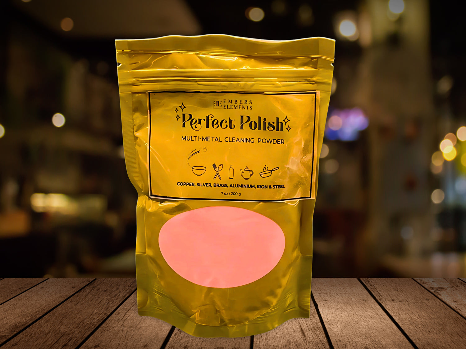 Yellow package of Perfect Polish multi-metal cleaning powder on a wooden surface with a blurred background.
