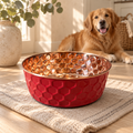 Golden Retriever lying down behind the RUBY pink diamond-hammered copper pet bowl on a woven mat